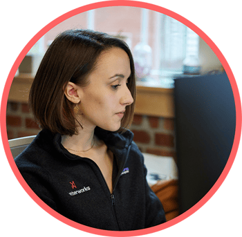 woman working on a desktop computer within a circle with a pink border